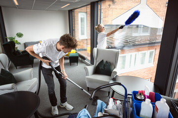Female and male housekeeping staff cleaning lobby together
