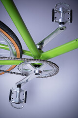 wheel of a bicycle, bike pedal, chain and green frame