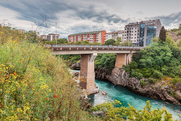 Podgorica, Montenegro's Moraca River flows beneath picturesque bridges, weaving through the...