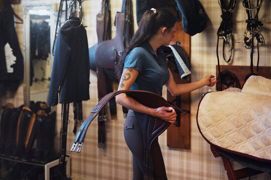 Side view of female animal trainer holding belt strap at ranch