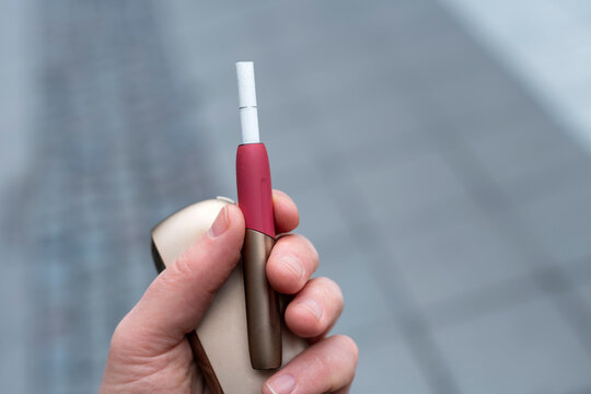 Hand holding e-cigarette and charger