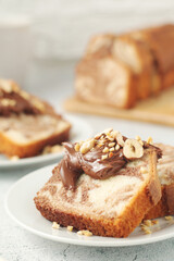 A piece of marble biscuit with chocolate cream and nuts