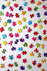 Colorful jigsaw puzzle pieces on white background. Flat lay.