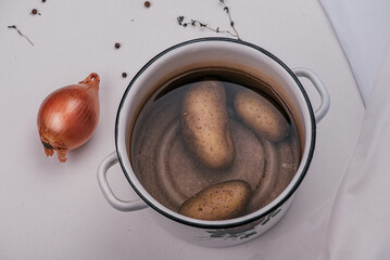 Potatoes in a pot before cooking, with onion, thyme 