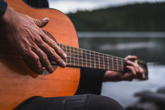 Cropped hand of man playing guitar