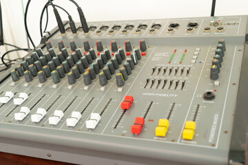 High fidelity audio mixing console with multiple knobs and sliders in a recording studio. Perfect for music production, sound engineering, and broadcast applications.