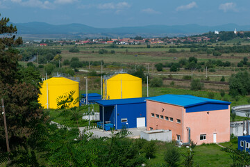 Industrial Facility with Yellow Tanks in Rural Landscape