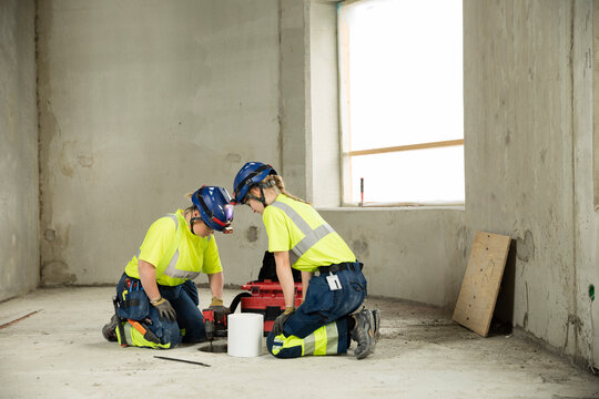Female civil engineers in protective workwear working at construction site