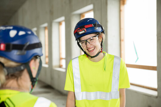 Smiling female engineers discussing while standing at construction site