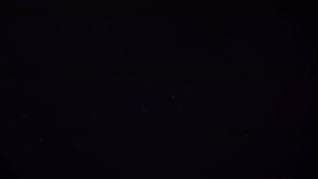 A flying allergen in the air. Dust particles move dynamically on an isolated black background. The perfect background to overlay your design. High quality 4k footage