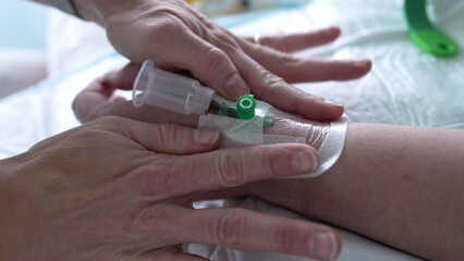 Hospital Nursing Care - Blood Sample Bottle Attached to Patient's Hand, Nurse Securing Straps