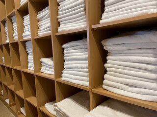 Sets of rolled terry towels on a shelf isolated on a light background.