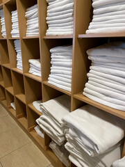 Sets of rolled terry towels on a shelf isolated on a light background.