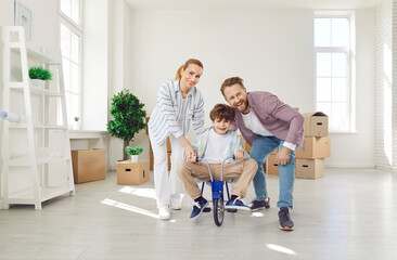 Portrait of parents and son celebrating relocation to a new home or real estate. The son is...