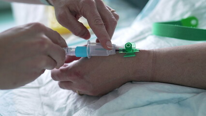 Nurse's hand taking blood from Patient's hand, close-up. hospital equipment and routine of nursing care