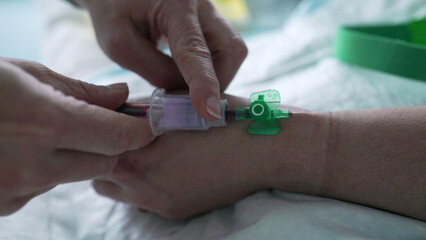 Nurse's hand taking blood from Patient's hand, close-up. hospital equipment and routine of nursing...