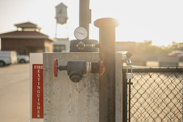 Water or gas pipeline with gate pressure valve installed on a concrete wall on the rooftop parking...