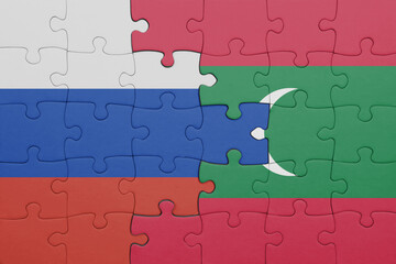 puzzle with the colourful national flag of maldives and flag of russia.