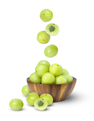 Indian gooseberry fruits or Amla (phyllanthus emblica) falling to wooden bowl isolated on white background.