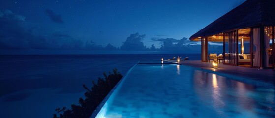 The photo shows a night view of an infinity pool on a tropical beach
