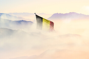 Belgium flag disappears in beautiful clouds with fog.