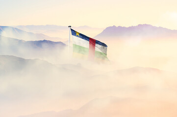 Central African Republic flag disappears in beautiful clouds with fog.