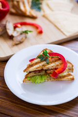 fried toast with chicken, salad, greens on a wooden table