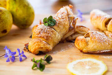 Sweet pastries, puff pastries with pears, on a wooden table