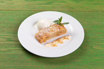 Strudel and a scoop of ice cream in a plate.