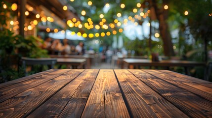 Empty wooden table top with blurred background of outdoor restaurant in the evening for product display montage.
