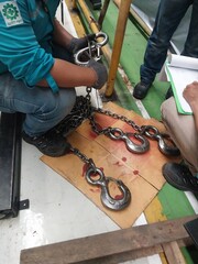Engineers are inspecting hooks for lifting safety crane steel In the factory auto parts license...
