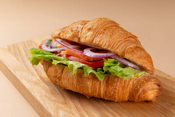 Croissant with salmon on a board.