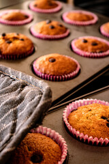 Fresh banana/chocolate chip muffins in muffin trays with pink cupcake papers