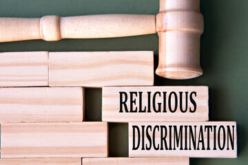 RELIGIOUS DISCRIMINATION - words on wooden blocks on a white background with a judge's gavel.