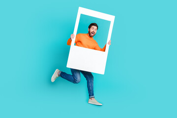 Photo of cheerful crazy man wear trendy clothes hands hold white frame cadre isolated on cyan color...