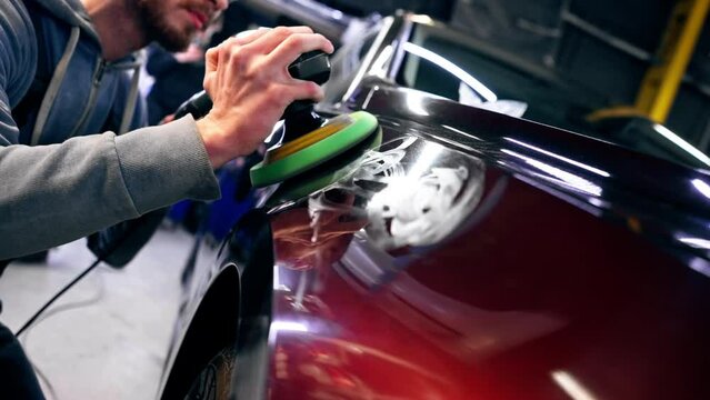 close-up of the hands of a car mechanic at a service station doing the final polishing to shine
