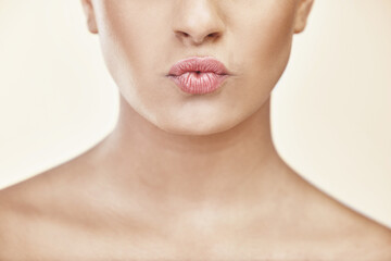 Woman, lips and kiss in studio for beauty with makeup, cosmetics and glow with pride for...