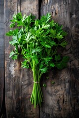 A bunch of fresh parsley is displayed on a wooden table. The parsley is green and fresh, and it is arranged in a way that makes it look like a bundle of sticks