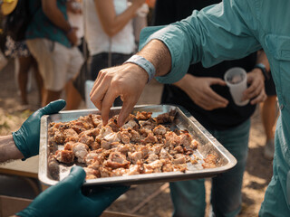 People Sampling Barbecue at Outdoor Festival During Daytime