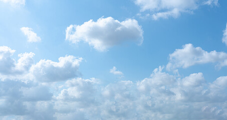 A bright summer day with fluffy white clouds in a clear blue sky
