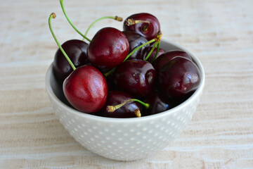 a bowl of dark red cherries isolated close up 