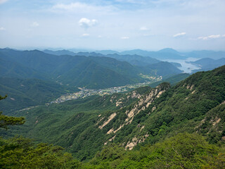 Obraz premium A mountain range with a town in the valley below. The sky is clear and the sun is shining