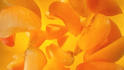 Fresh apricots pieces falling into water, top down view