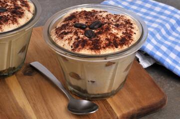 Tiramisu au café dans des ramequins avec une cuillère en gros plan