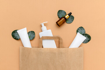 Cosmetic cream in white plastic containers. Craft bags. Eucalyptus leaves.