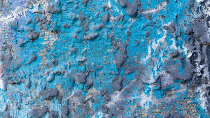 Cyan blue wrinkled old concrete wall splashed with gray paint.