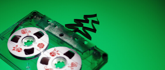 Banner, green background, with transparent plastic audio cassette with Red prints of Christmas toys...