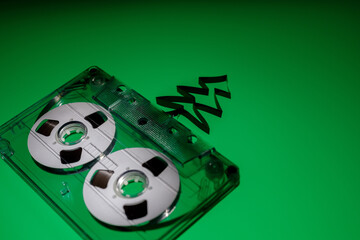 Green background, with transparent plastic audio cassette with white discs. and Christmas tree from...