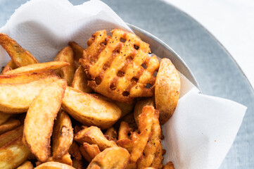 Various types of French fries made in the home fryer full of oil, unhealthy food.