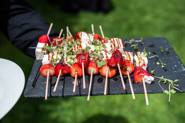 Strawberry skewers with cheese and sweet vinaigrette, at a luxury event, at a celebration.